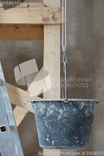 Image of Dirty bucket and ladder on wall background