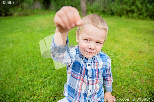 Image of Happy little boy showing something