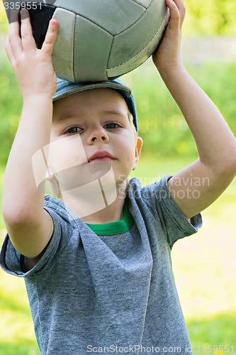 Image of Little boy holding sport ball