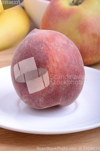 Image of peach,  apple and strawberry on wooden plate 