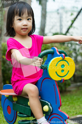 Image of Asian Kid Riding at Park