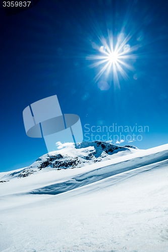 Image of Sun and snowy mountain.