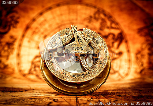 Image of Vintage compass lies on an ancient world map.