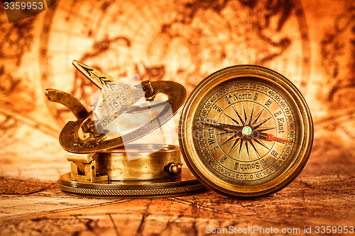 Image of Vintage compass lies on an ancient world map.