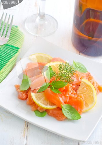 Image of fresh salmon with lemon on the white plate