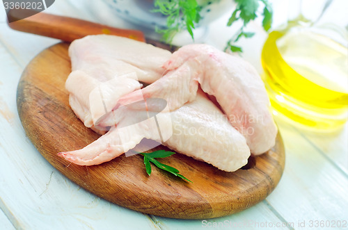 Image of Raw chicken and knife on the wooden board