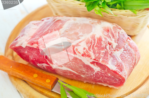 Image of raw meat and knife on the wooden board