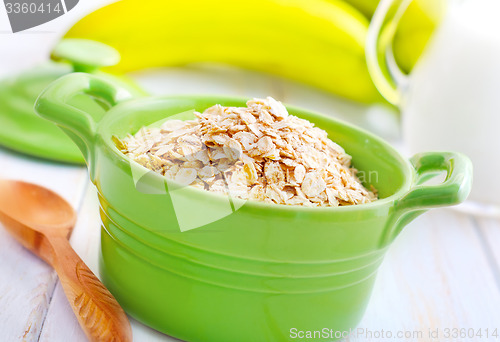 Image of Oat flakes in the green bowl with banana and milk