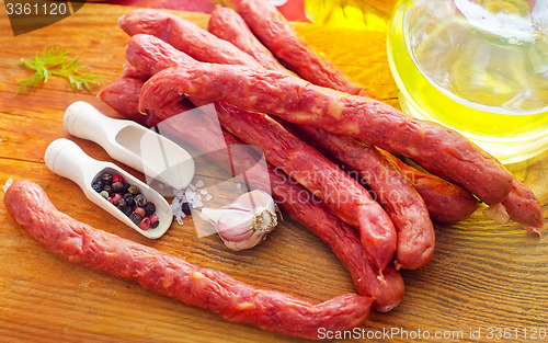 Image of sausages on the wooden table with aroma spice