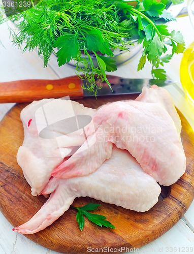 Image of Raw chicken and knife on the wooden board