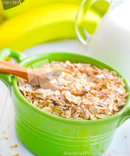 Image of Oat flakes in the green bowl with banana and milk