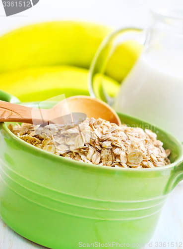 Image of Oat flakes in the green bowl with banana and milk