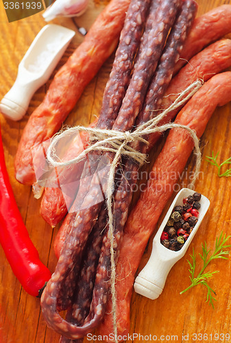 Image of sausages on the wooden table with aroma spice