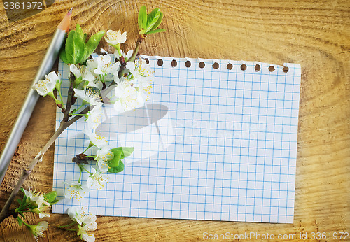 Image of flowers and note on wooden background