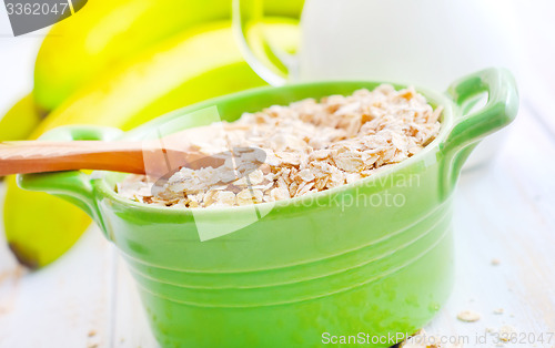 Image of Oat flakes in the green bowl with banana and milk