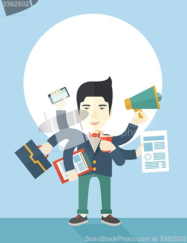 Image of Young but happy japanese employee doing multitasking office tasks.