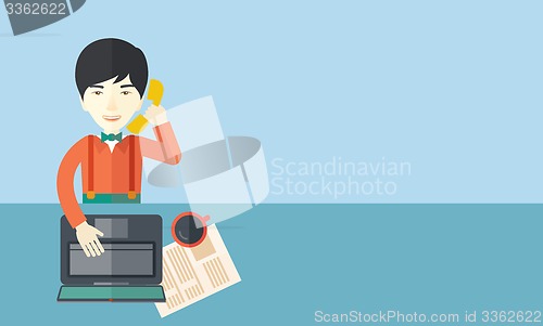 Image of Chinese office man sitting at his working desk. 