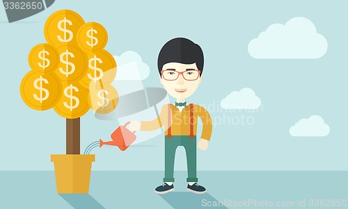 Image of Asian businessman happily watering the money tree.