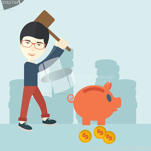 Image of Chinese guy holding a hammer breaking piggy bank.