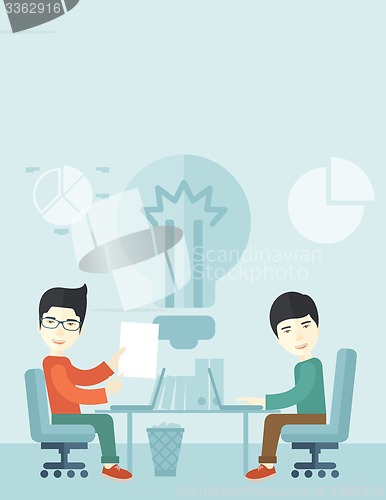 Image of Two japanese businessmen sitting working together.