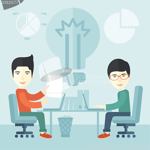 Image of Two japanese businessmen sitting working together.