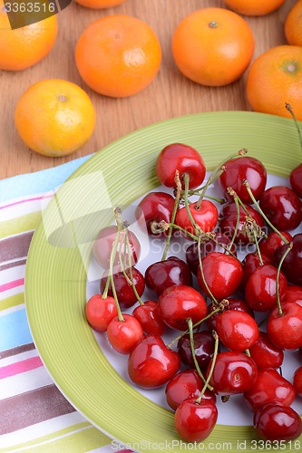 Image of mandarin and cherry fresh fruits and berries, summer health food