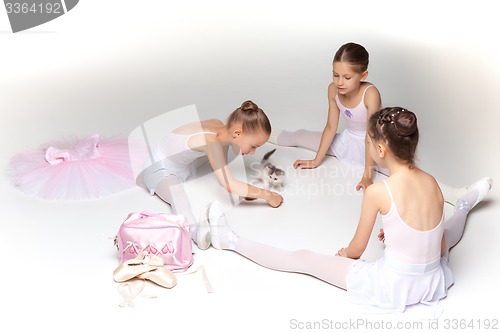 Image of Three little ballet girls sitting and posing together