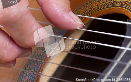 Image of Old woman\'s hand playing guitar
