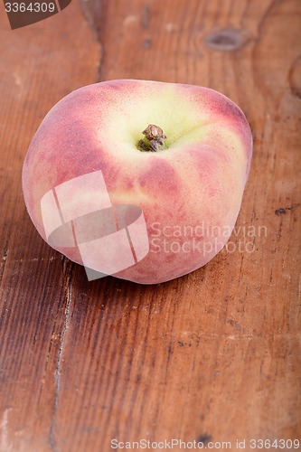 Image of Peach on wooden plate