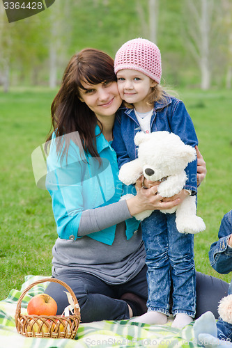 Image of Mother hugs daughter at a picnic