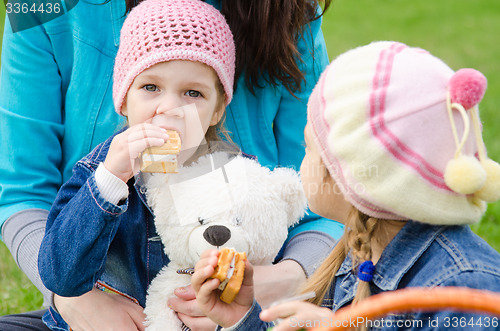 Image of girl sitting on his lap mother eats cake