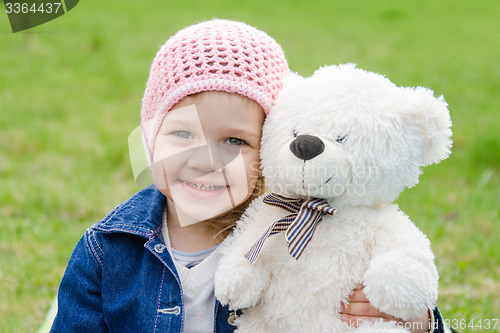 Image of Girl hugging a teddy bear picnic