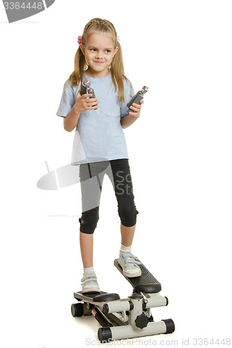 Image of Six year old girl on a step simulator with expander in the hands of