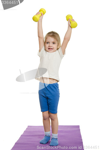 Image of Four-year-girl lifted dumbbells over a