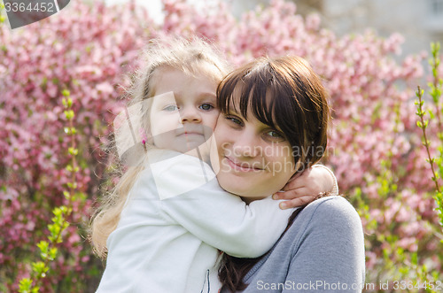 Image of Embraces of mother and daughter on spring background