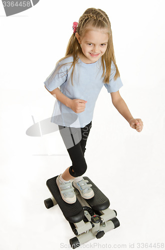 Image of Six year old girl is engaged on a step simulator