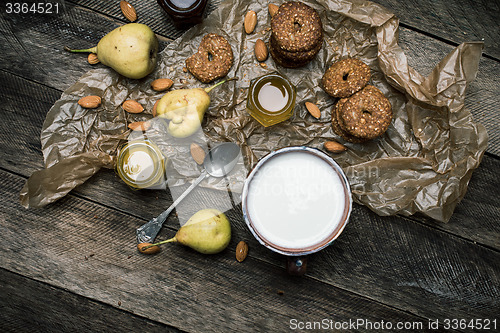 Image of Tasty pears Cookies and milk on wooden table