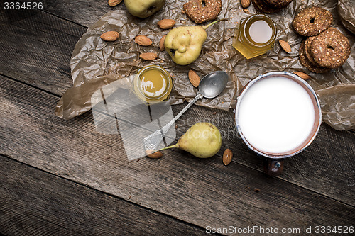 Image of Nuts pears Cookies and milk on wooden table