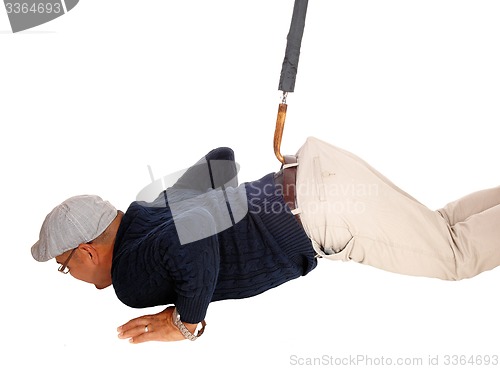 Image of Man lying on floor pulled up with umbrella.
