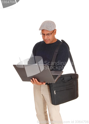 Image of A Hispanic man working on his laptop.