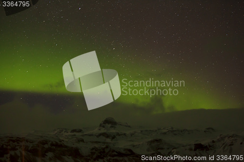 Image of Northern lights with snowy mountains in the foreground