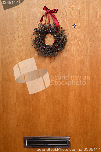 Image of wooden door with a Christmas wreath and mailbox