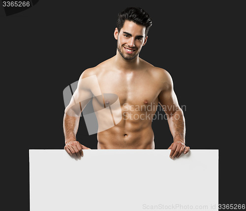 Image of Sexy young man holding a cardboard