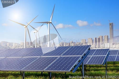 Image of Solar panels and wind turbines with city