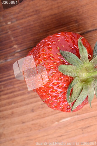 Image of Strawberry on wooden plate close up
