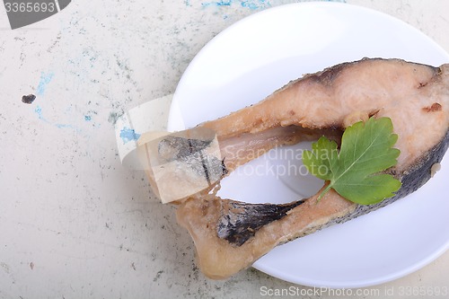 Image of Frying pan with one roasted salmon steaks, view from above