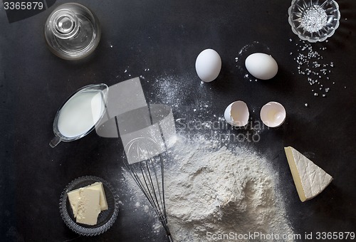 Image of Dough on black table with flour and ingredients