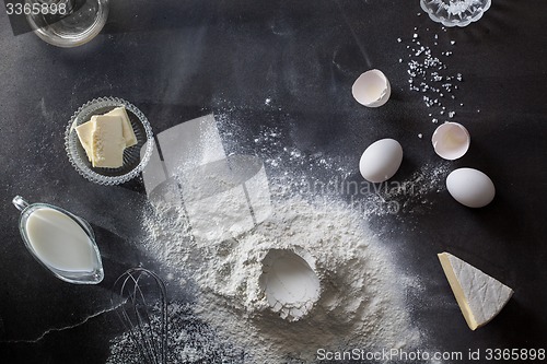 Image of Dough on black table with flour and ingredients