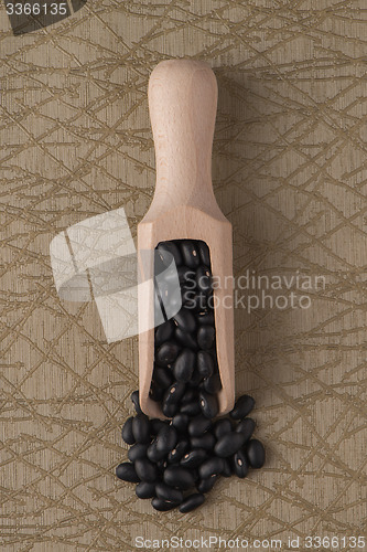 Image of Wooden scoop with black beans
