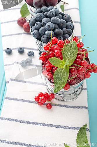 Image of Red currants and blueberries in small metal buckets